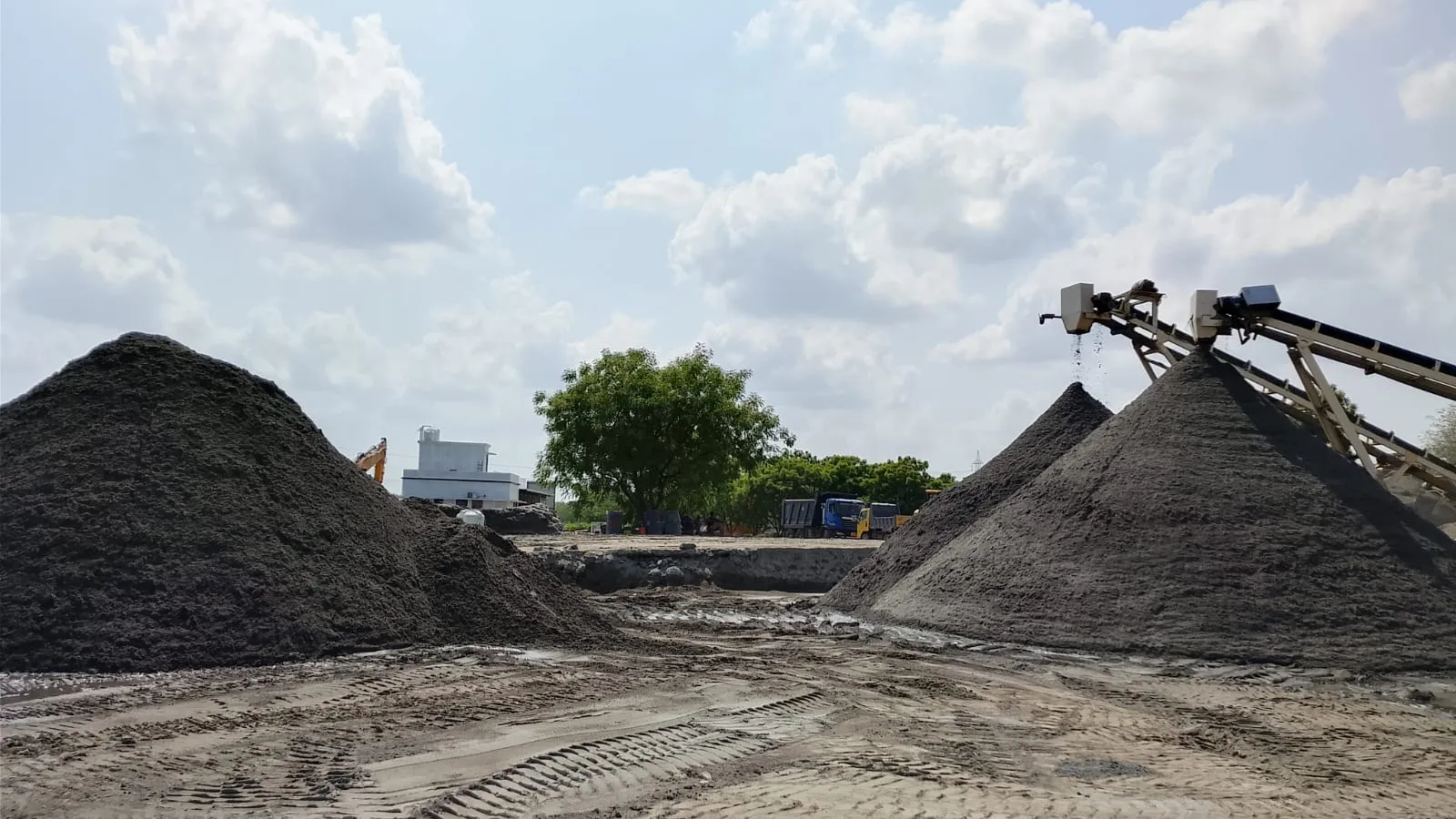 M-Sand stockpiles alongside delivery tipper trucks at Tirupati Balaji Blue Metals LLP plant yard, Virudhunagar
