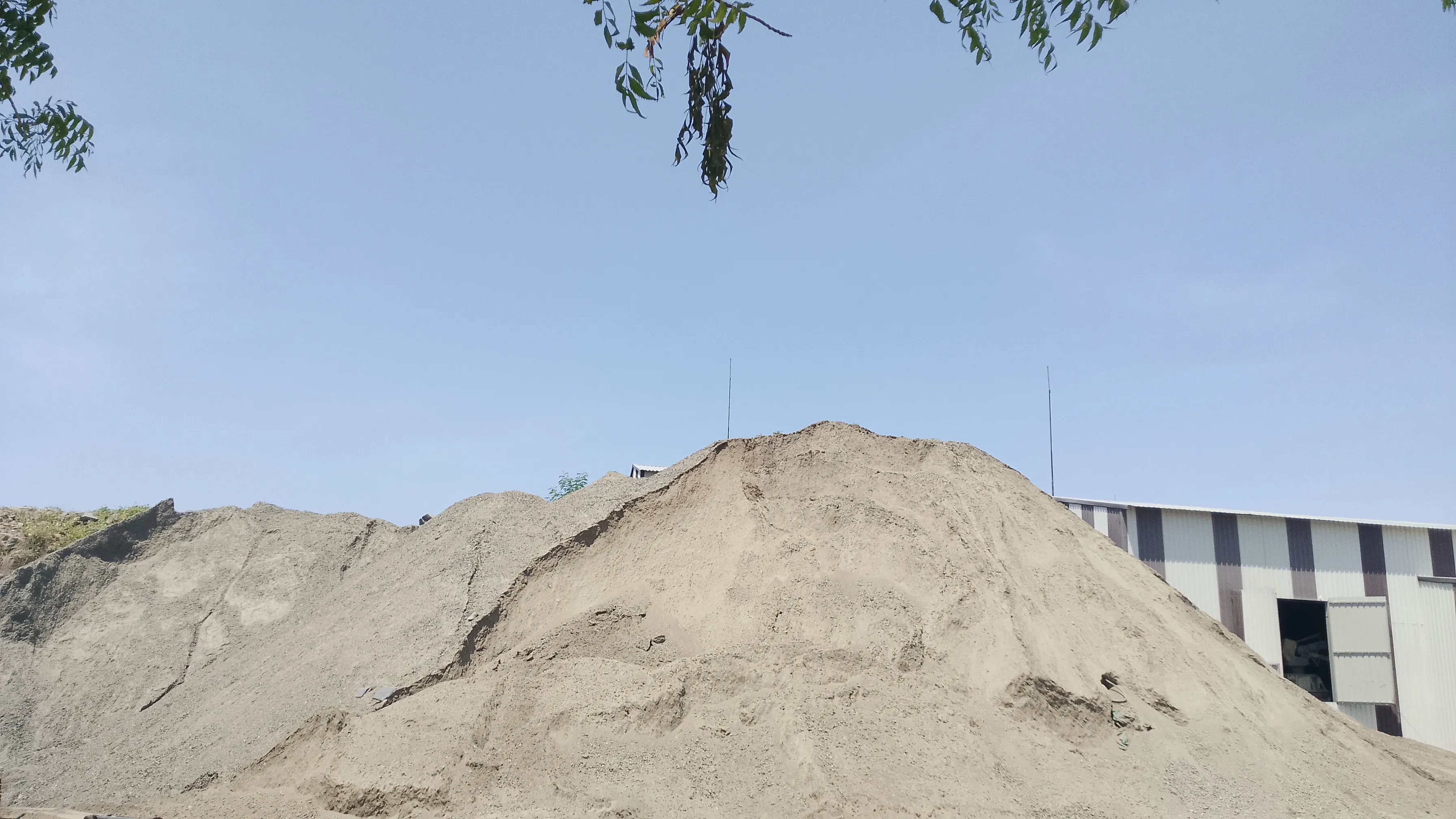 Wheel loader handling GSB-WMM road base aggregate material at Tirupati Balaji Blue Metals LLP yard, Virudhunagar, Tamil Nadu